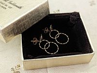 Pair of three linked hammered gold hoops earrings displayed in an open vintage box with black velvet lining