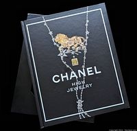 Front cover of the Chanel High Jewelry book featuring an ornate jewelry design with lion and stars embossed in gold and silver.