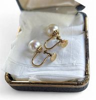 Photo of the pair of vintage screw back earrings inside the original jewlery box with white cloth lining