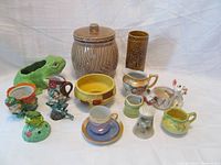 Full view of all vintage porcelain items including cookie jar, various planters, vases, creamers, and figurines.