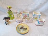 Full lot showing various vintage Japanese porcelain planters and decorative items including figures, square and bootie-shaped planters, and a decorative plate.