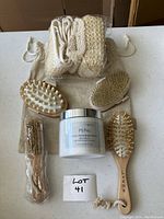 Overview showing all items in lot including body butter jar, scrubbers, and wooden massage brushes.