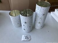 Three light up glass vases standing upright showing size differences and star pattern detail.
