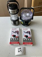 Two portable lantern lamps and two boxed SecuriBoost portable door locks, all items arranged on a table for visibility.