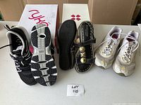 Overall image showing the three pairs of footwear: two runner shoes and one pair of black leather sandals.