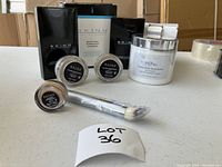 Photo shows full cosmetic package with four cosmetic containers and a brush