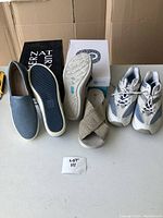 Photo showing the three pairs of footwear: blue slip-ons, beige sandals, and white-blue runners.