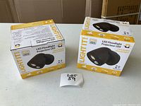 Two boxed LightIt LED floodlights side by side, showing the product and packaging.