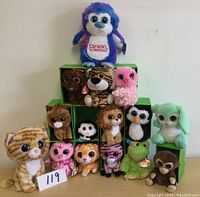 Full view of 15 assorted big eyes stuffed animals arranged in a display, with various animal designs including owls, tiger, cat, frog, penguin, and others.