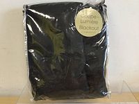 Black blackout curtains folded and packaged in labeled clear plastic wrapping