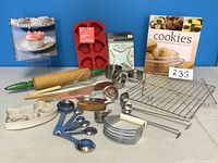 Entire baking set included in the lot showing cookbooks, rolling pin, silicone pan, cookie cutters, measuring spoons, spatulas and cooling rack.