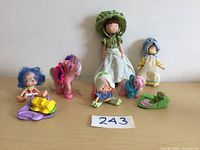 All items arranged on a table: five dolls, two My Little Pony figures, and accessories.