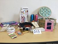 Wicker sewing basket with sewing accessories and patterns on table