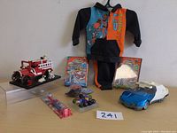 Full lot showing basketball outfit, toy cars, marbles, toothbrush, and other items