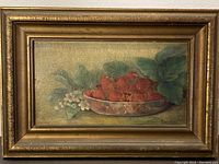 Full view of the still life oil painting showing strawberries in a bowl and white flowers, along with the gold frame.