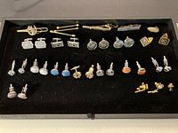 Full view of the entire lot showing multiple cufflinks in rows and two bolo ties at the top.