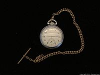 Full view of pocket watch with curb chain and T-bar on black background