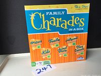 Front of Family Charades In-A-Box Compendium game box showing colorful game pack titles and branding