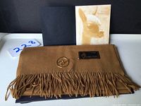 Scarf folded with original packaging and brochure showing an alpaca image.