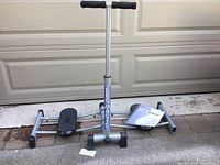 Leg Magic exercise machine shown from a side angle with instruction manual and a small price card.