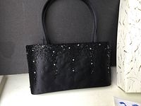 Front side of the black handbag showing sequin decoration.