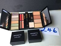 Open Steiner eye shadow palette showing various colors, lip gloss tubes, and makeup compartments with mirror panels.