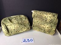 Two green circular patterned fabric bags: one rectangular with front pocket, one foldable organizer with compartments