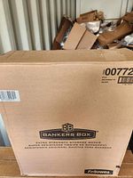 Front view of closed cardboard box showing Bankers Box logo and product description indicating extra strength storage boxes inside.