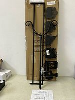 Metal frame and parts of Evergreen stocking holder on a table with cardboard background