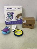 Photo showing Dog Puzzle Toy box, two small pet toys, and sealed Chew & Fun Toy Kit box