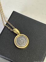 Close-up photo of the saint pendant showing detailed engraving and gold-plated 925 silver bezel.