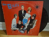 Front cover of The B-52's Wild Planet LP with band photo and orange background.
