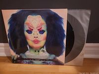 Front cover of Bjork's Utopia album showing unique surreal artwork with a face and abstract elements.