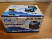 Box front showing HD 1080p video logo, image of the camera and car, and branding as Vehicle Blackbox DVR.