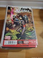 Stack of comic books bagged and boarded, showing X-Force #003 on top with Marvel Now! branding and clear protective sleeves.