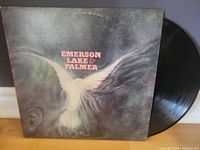 Front cover of the Emerson, Lake & Palmer self-titled LP displaying the album artwork featuring a white dove in flight over a blurred background, vinyl record partially visible.