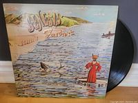 Front cover of Genesis Foxtrot vinyl LP showing artwork of character in red coat with fox mask standing on dock and ocean scene.