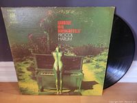 Front cover of Procol Harum Shine On Brightly vinyl record featuring a surreal image of golden mannequin before a piano in an outdoor setting.