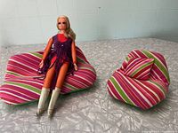 Groovy Barbie doll seated on striped Dream House couch with matching chair and cushion nearby