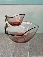 Side view of pink ombre chip and dip glass bowls with metal hanging stand showing overall shape and colors.
