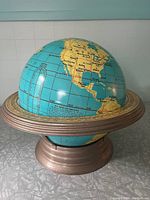 Full view of Cram's Beginner's Globe mounted on a metallic finish stand, showing western hemisphere continents across a blue ocean.