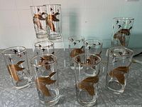 Full set of 10 highball glasses with flying geese gold pattern displayed on a table.