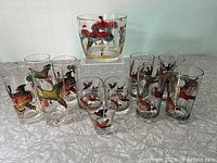 Full set displayed on table including ice bucket on clear stand and cocktail glasses grouped in front, showing pheasant hunting designs.