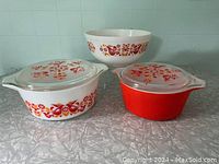 Full view of all three Pyrex Friendship pattern dishes: two casseroles with lids and one bowl.
