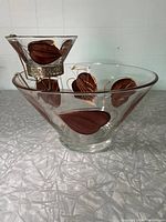 Side view of large chip bowl with smaller dip bowl fitted in metal hanger showing leaf and gold accents on clear glass.