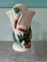 Front view of the vintage Regal USA vase showing crane egret and floral raised design with green and brown accents on white ceramic.