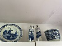 Full lot overview showing large decorative bowl, two tall decorative bottles, and matching plant pot all in blue and white ceramic