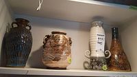 Lot overview photo showing three ceramic vases and one hanging oil lamp.