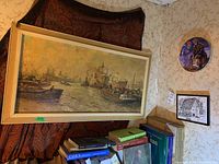 Framed oil painting of harbor scene with boats and ships, visible signature by Kees Molema, with part of decorative plate and small framed print seen nearby.