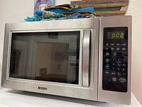 Kenmore microwave with stainless steel front and digital keypad showing time 0:00